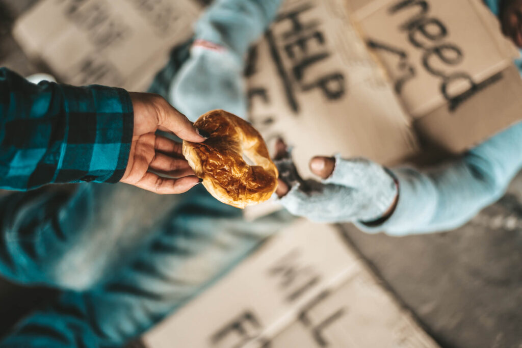 Hand offering pastry to another person.