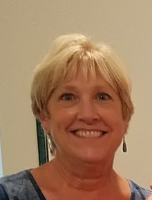 Smiling woman with short blonde hair.