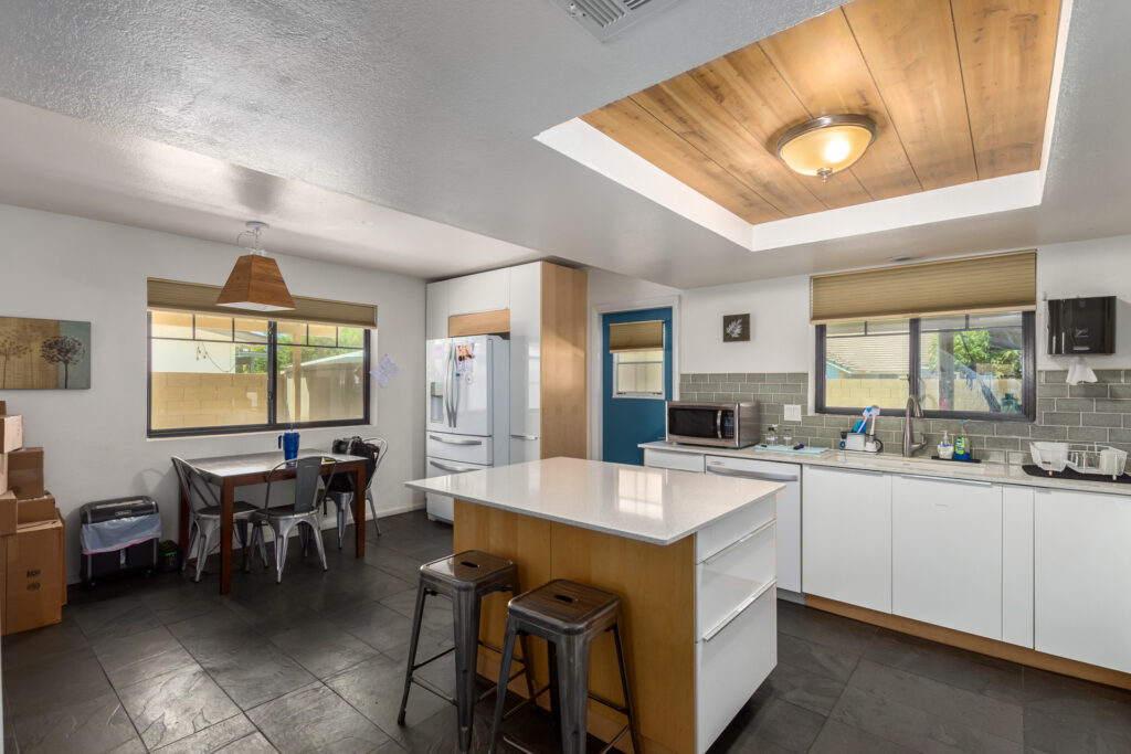 Modern kitchen with island and dining area.