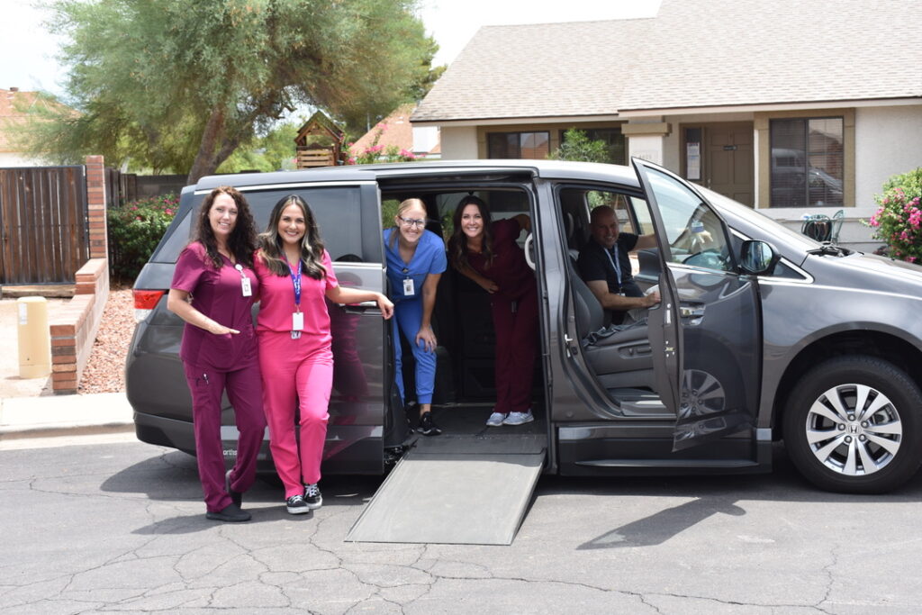 Healthcare workers posing by a van.