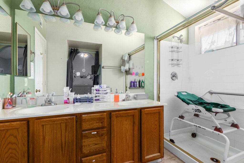 Modern bathroom with dual sinks and shower.